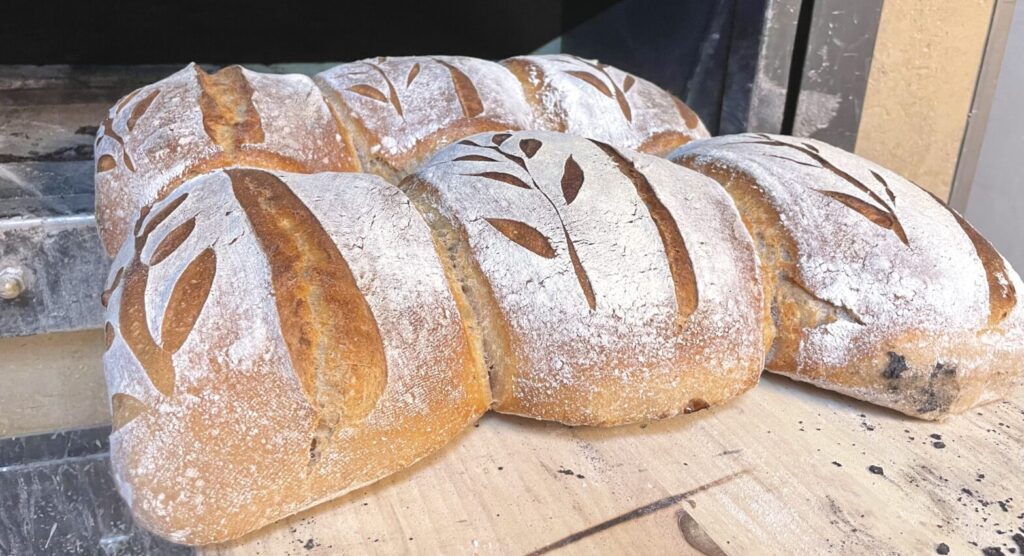 Schön verziertes Brot aus weizen vom Backhaus der Vielfalt frisch gebacken vor dem Holzofen