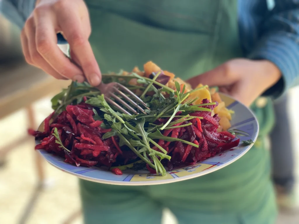 Frische Ernte auf dem Teller: Nahaufnahme eines bunten, gesunden Gerichts mit Rote-Bete-Salat und Rucola – direkter Genuss aus dem Anbau der Gartencoop.